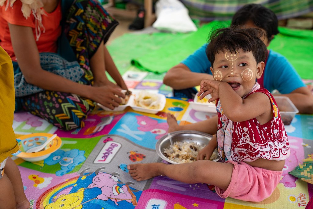 A boy in Myanmar eats a meal.