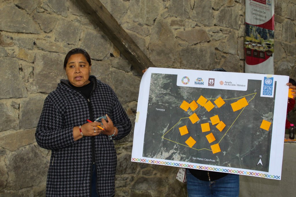 A woman in Mexico stands in front of a map