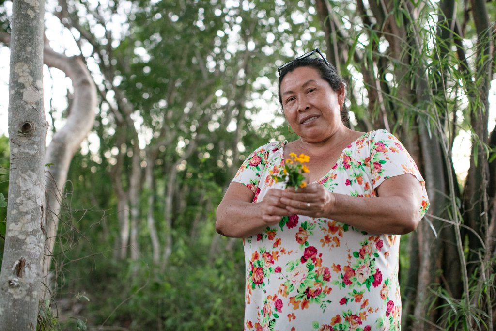 A woman in Mexico holds a flower.