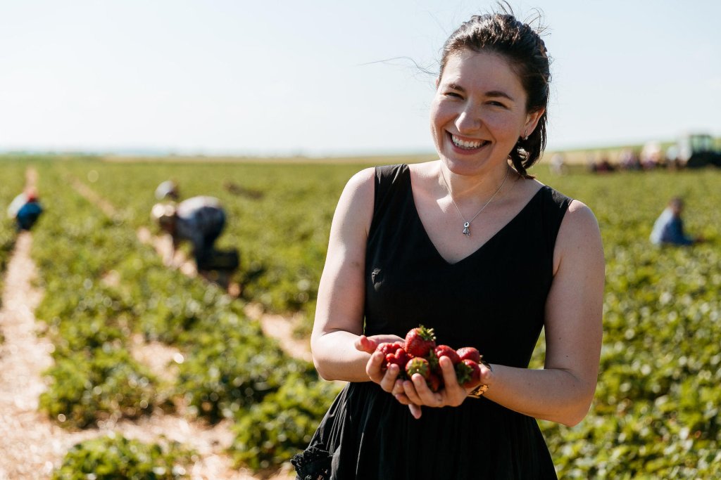 A woman in farmer in Moldova holds strawberries.