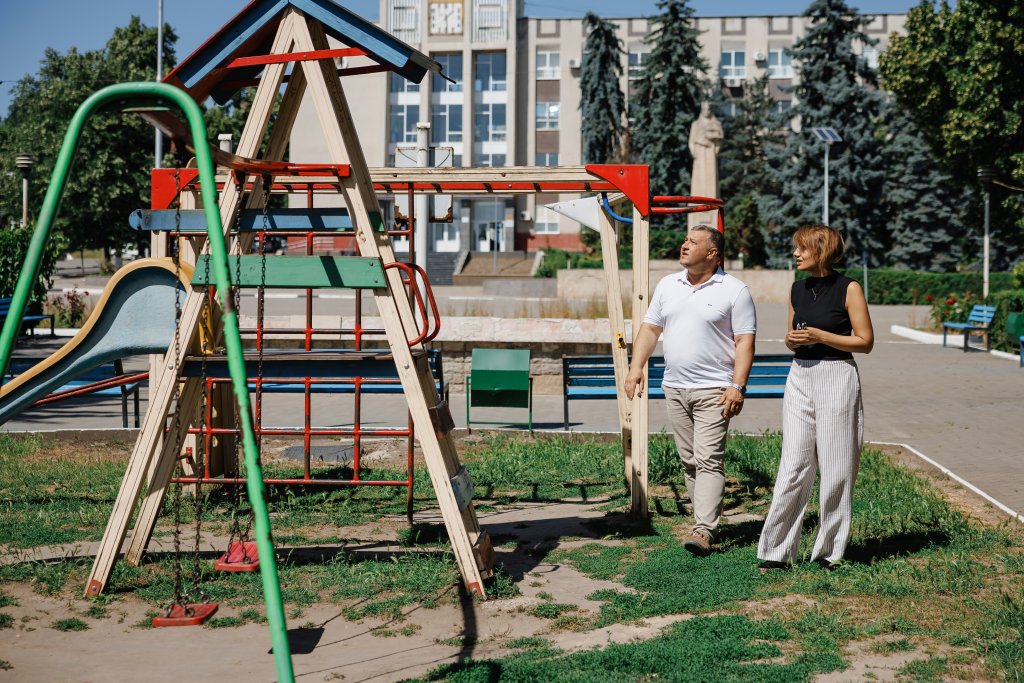 Two people in Moldova inspect a playground.
