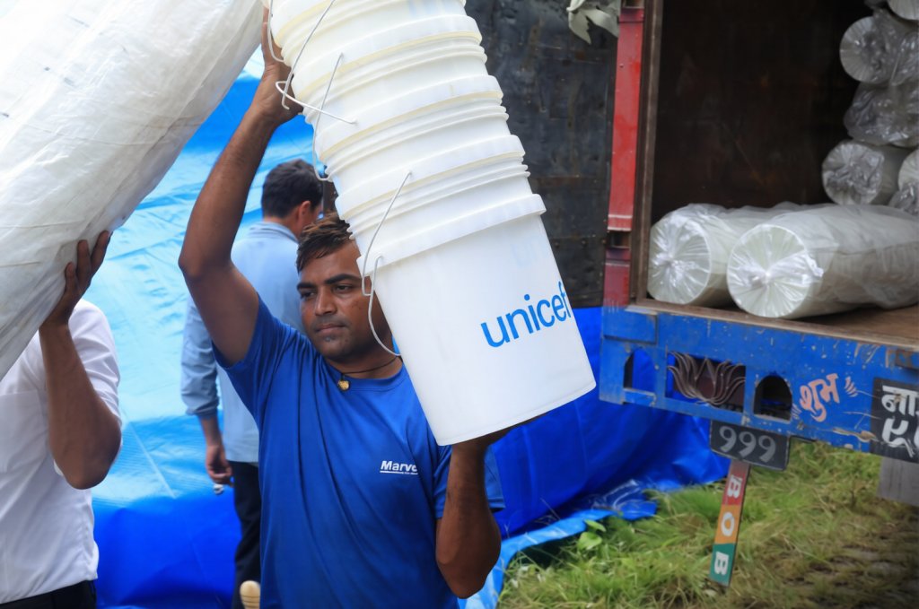 An aid worker distributes supplies following floods in Nepal.