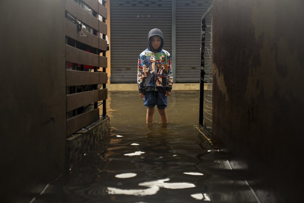 A boy in Thailand stands in floodwater.