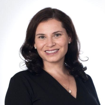 A woman in a black dress smiles at the camera.