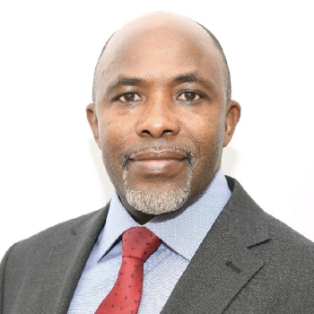 A man in a red tie smiles directly at the camera.