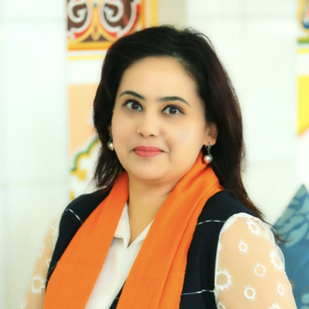 An elegant woman with an orange scarf and black hair looks at the camera. 
