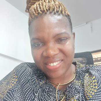 woman in patterned top smiles at camera 