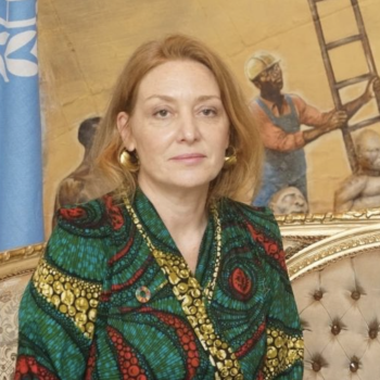 Resident Coordinator standing in front of a colourful background