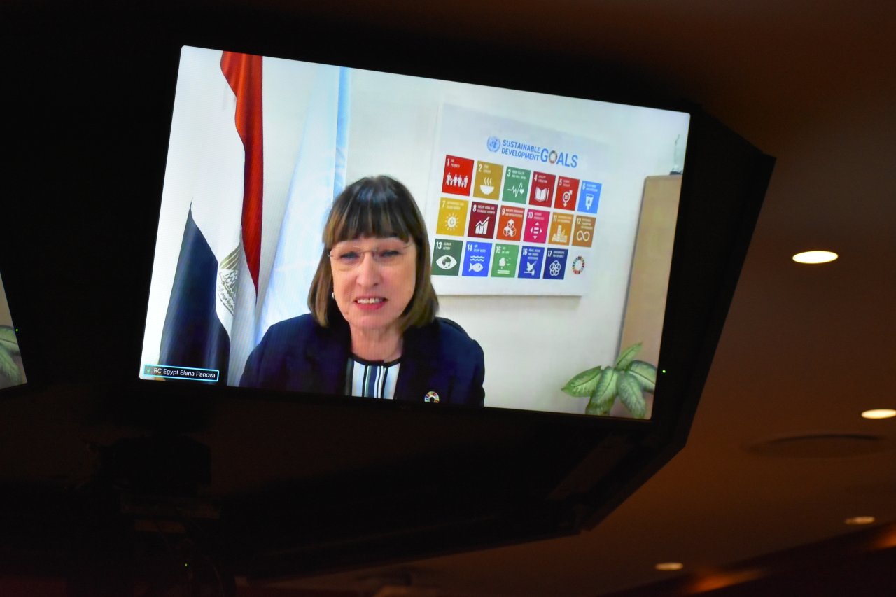 woman in dark suits speaks from a TV screen 