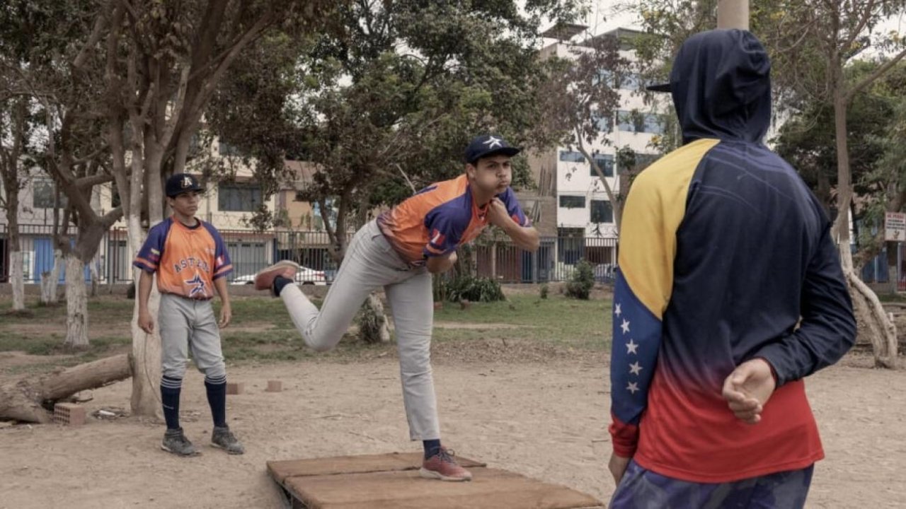 two young boys play baseball outside 