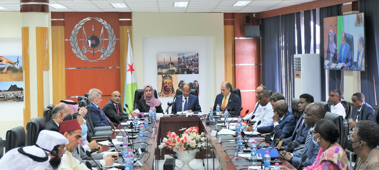big meeting of people sit around a table 
