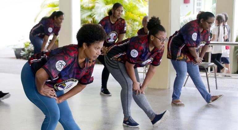 group of women stand stretching together 