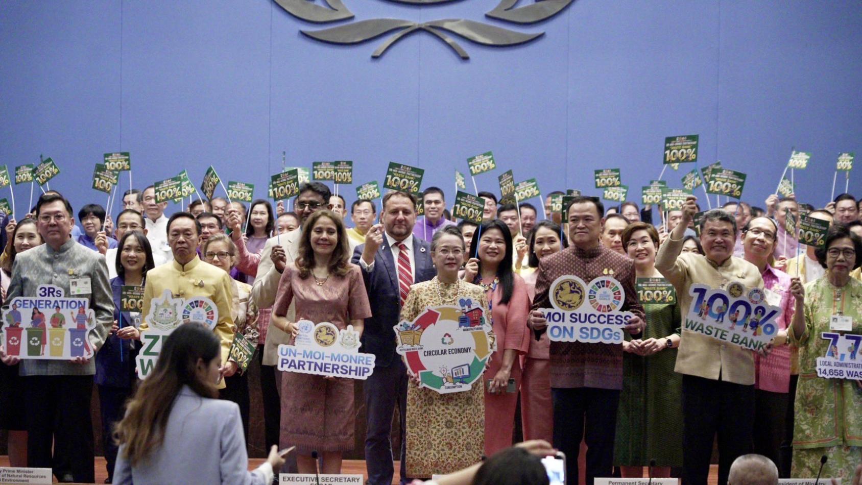 A group of people hold banners and smile at the camera