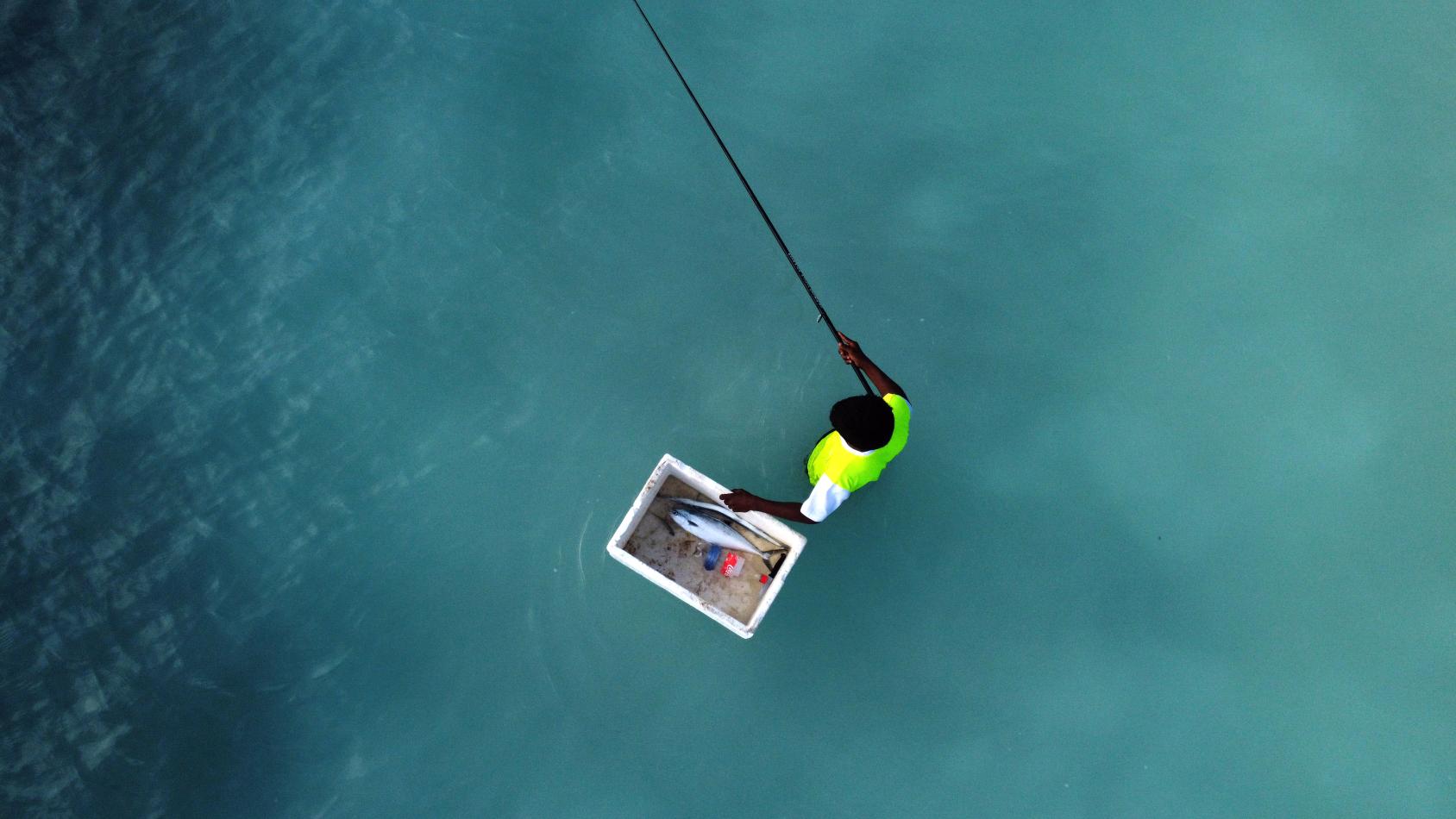 An aerial view of a lone fisherman