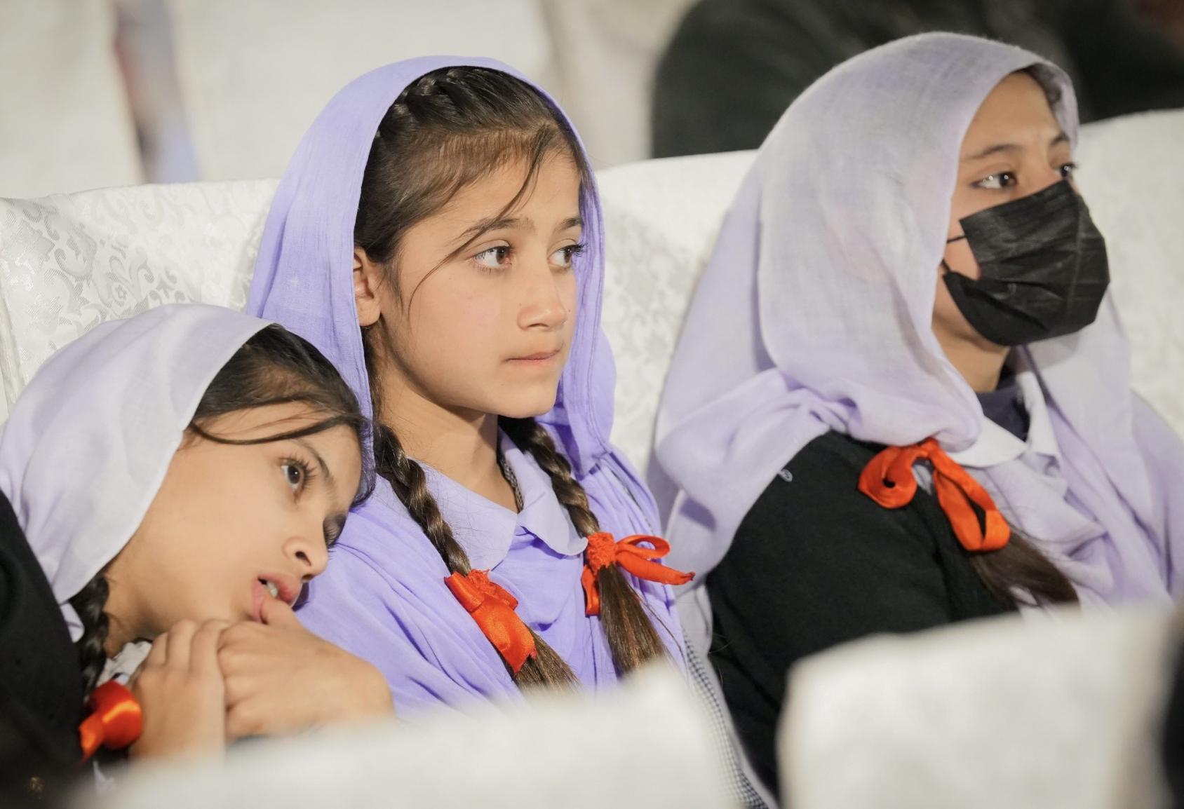 A group of young girls seated in an auditorium