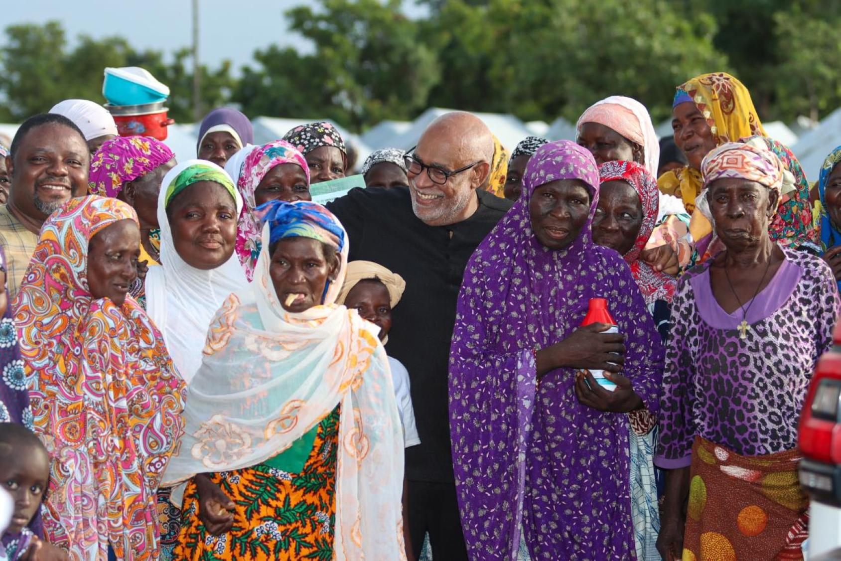 UN Resident Coordinator in Ghana with a group of asylum seekers, mostly women, symbolizing community support for vulnerable populations in Ghana