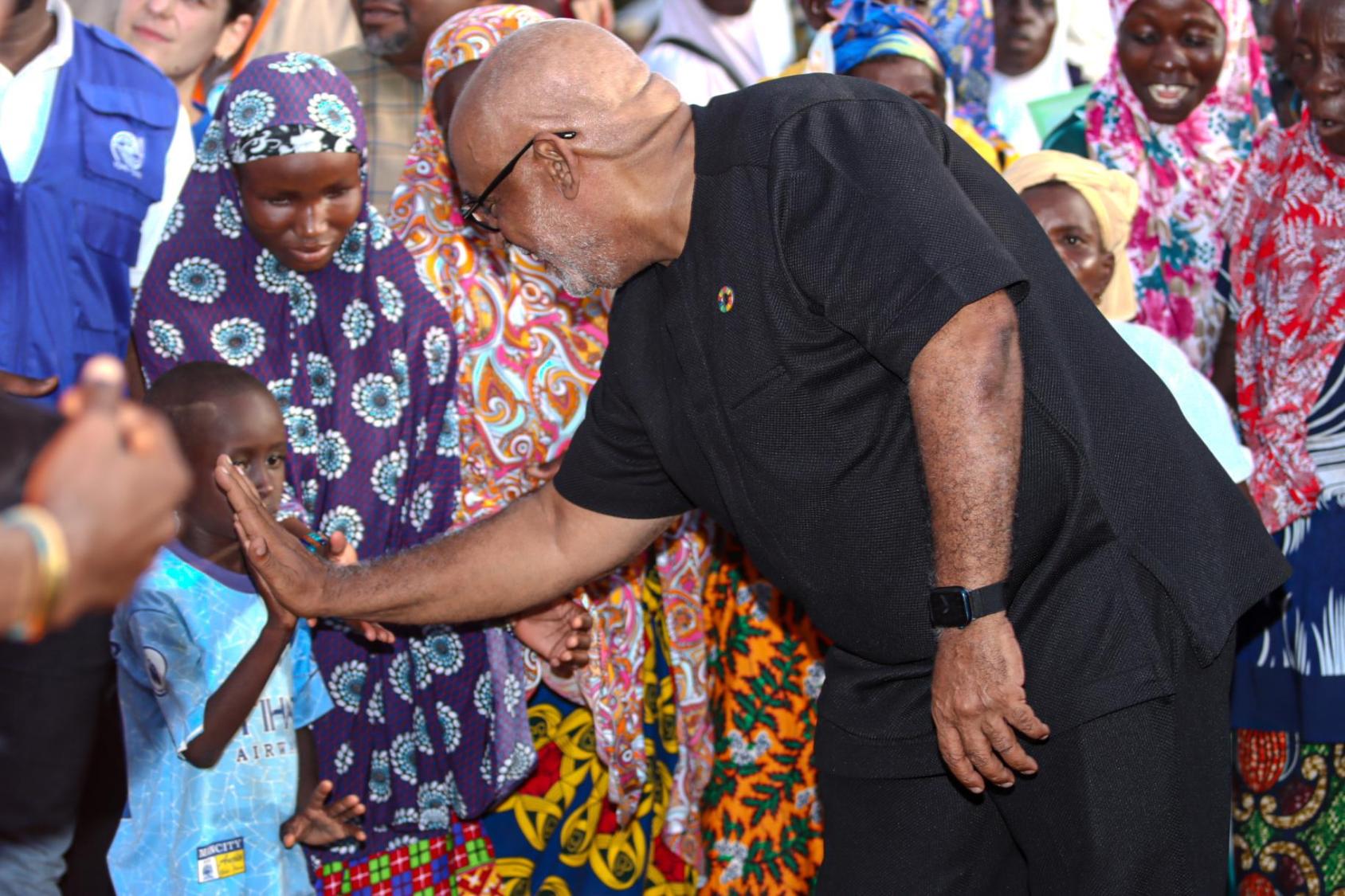 UN Resident Coordinator in Ghana interacting with a child, demonstrating UN support for asylum seekers