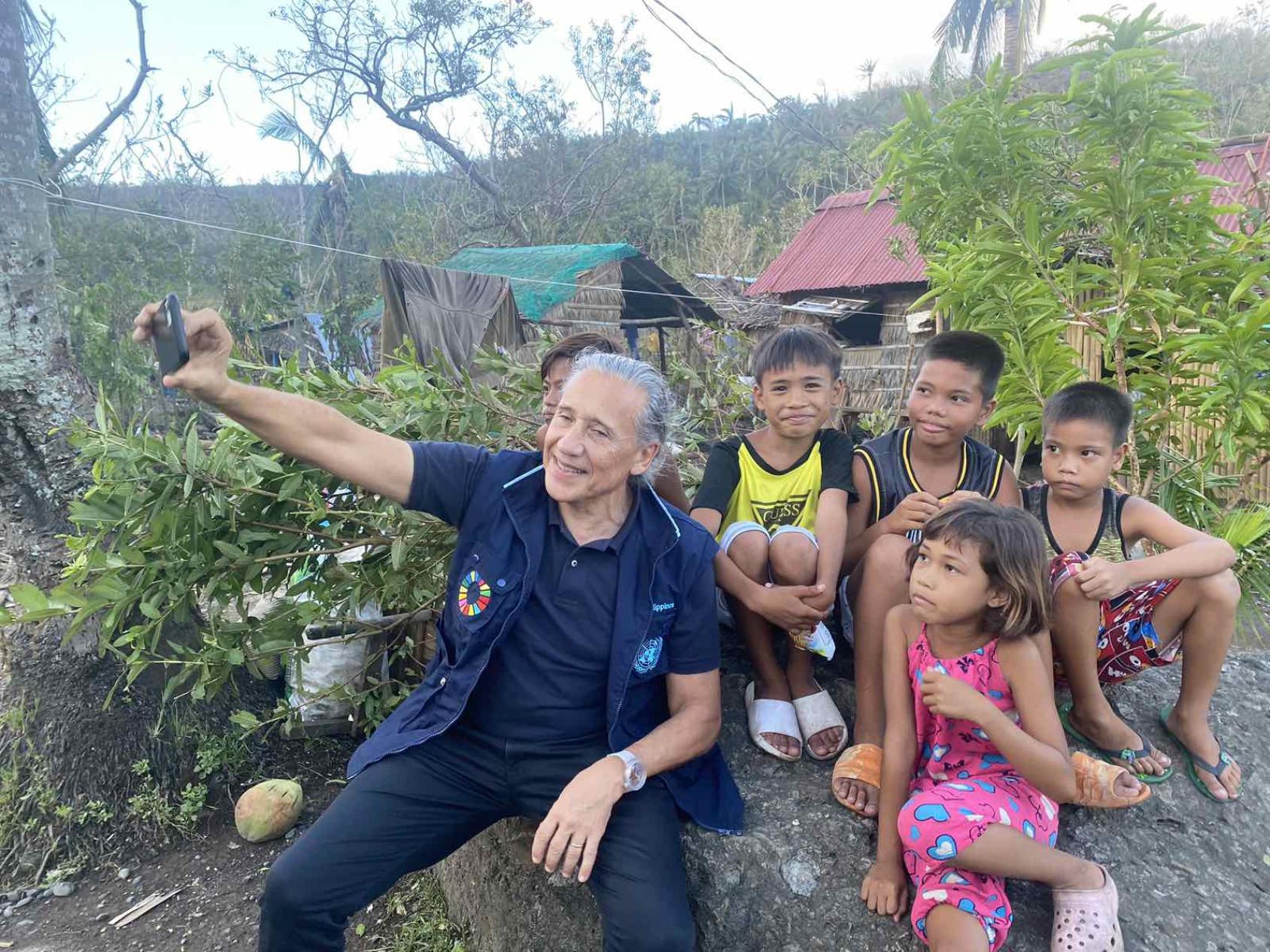 The Resident Coordinator takes a selfie with young children