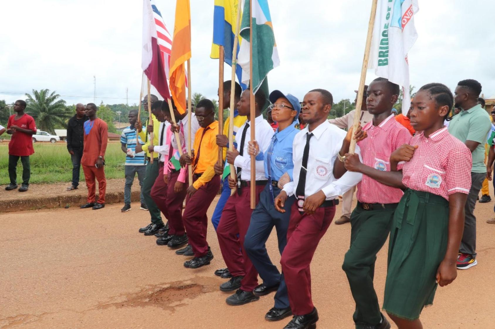 A group of children holding flags and walking outside