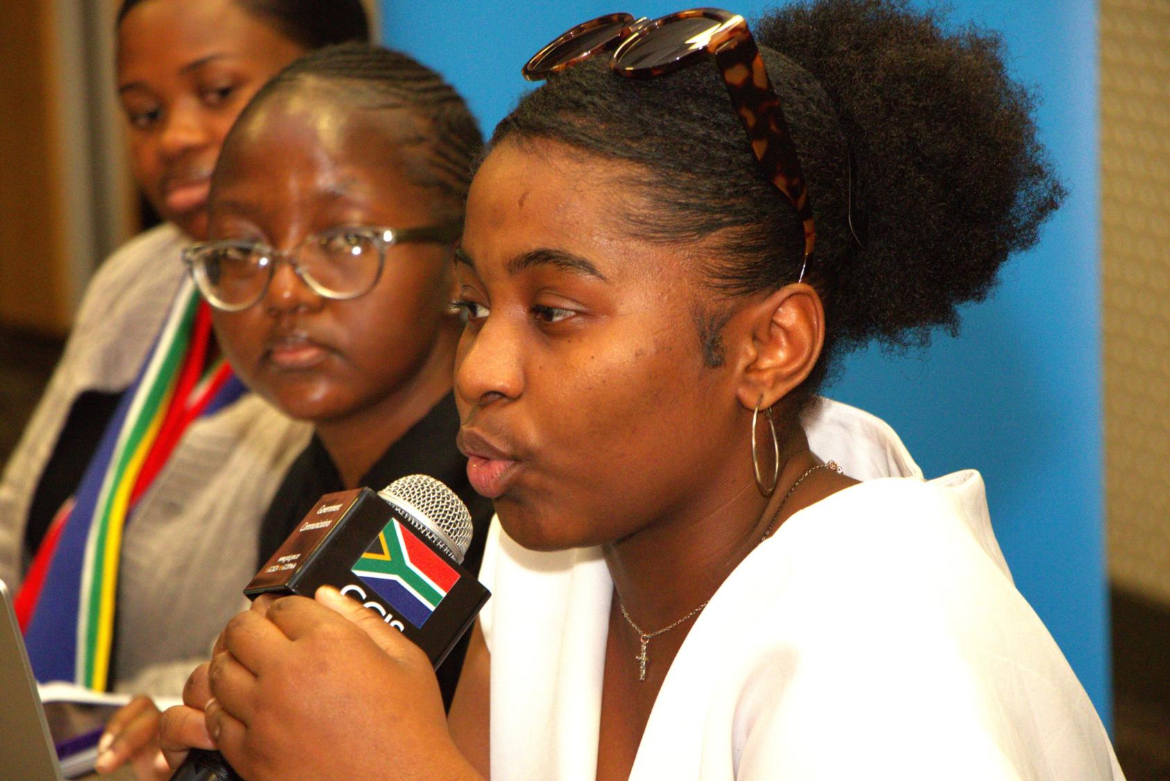 A young woman holding a microphone in her hand