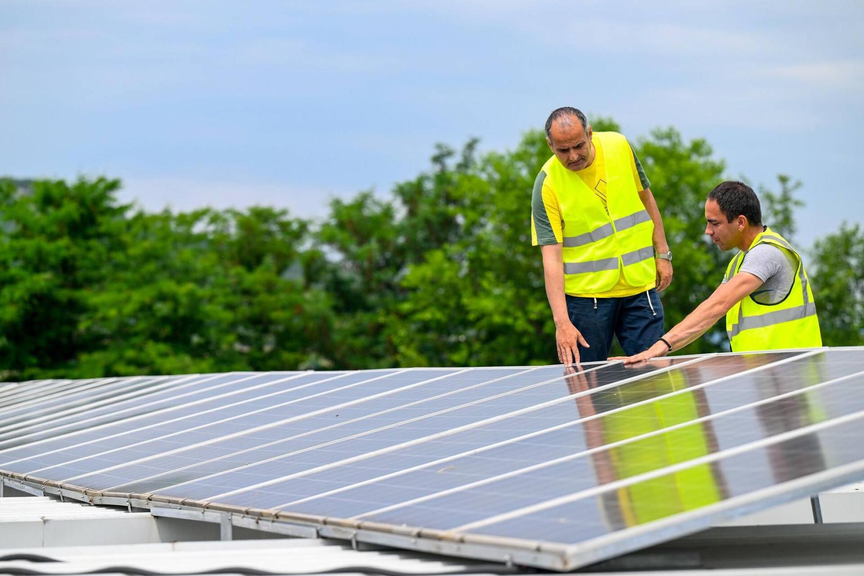 Two men are looking at a solar panel