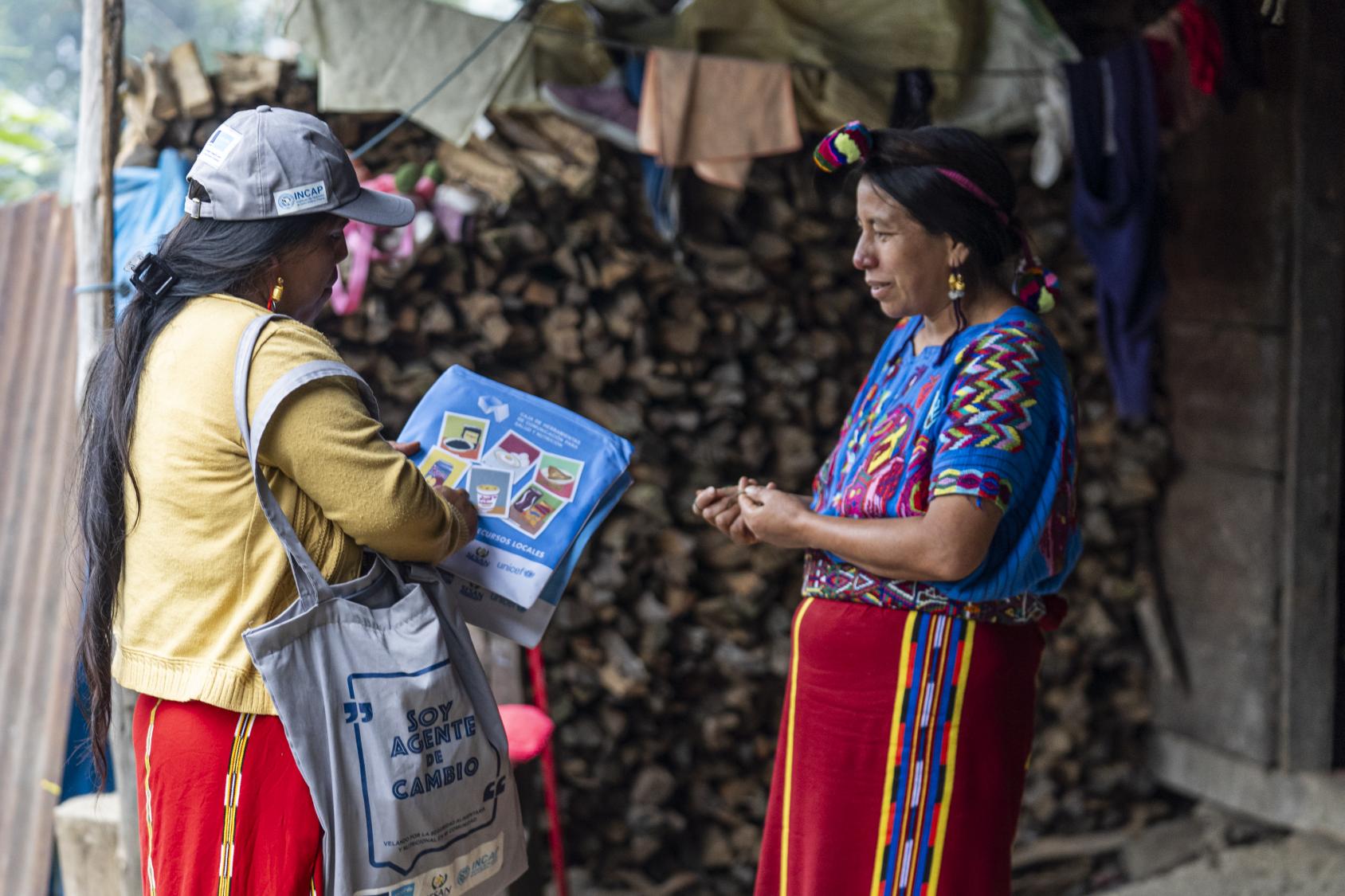 A woman is collecting information from two people outside their home