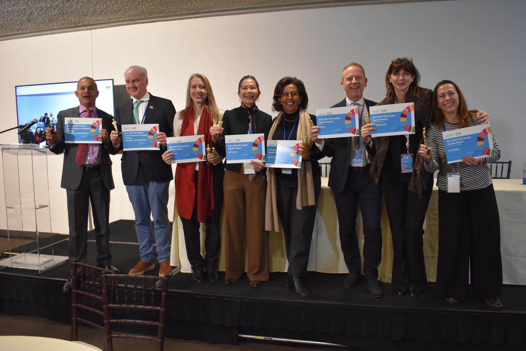 A group of people looking at the camera and smiling, holding their certificates 
