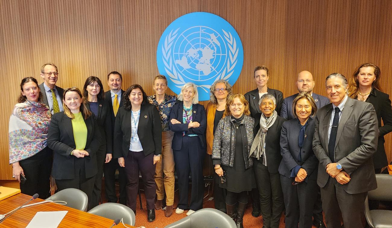 group of people standing in front of UN sign 