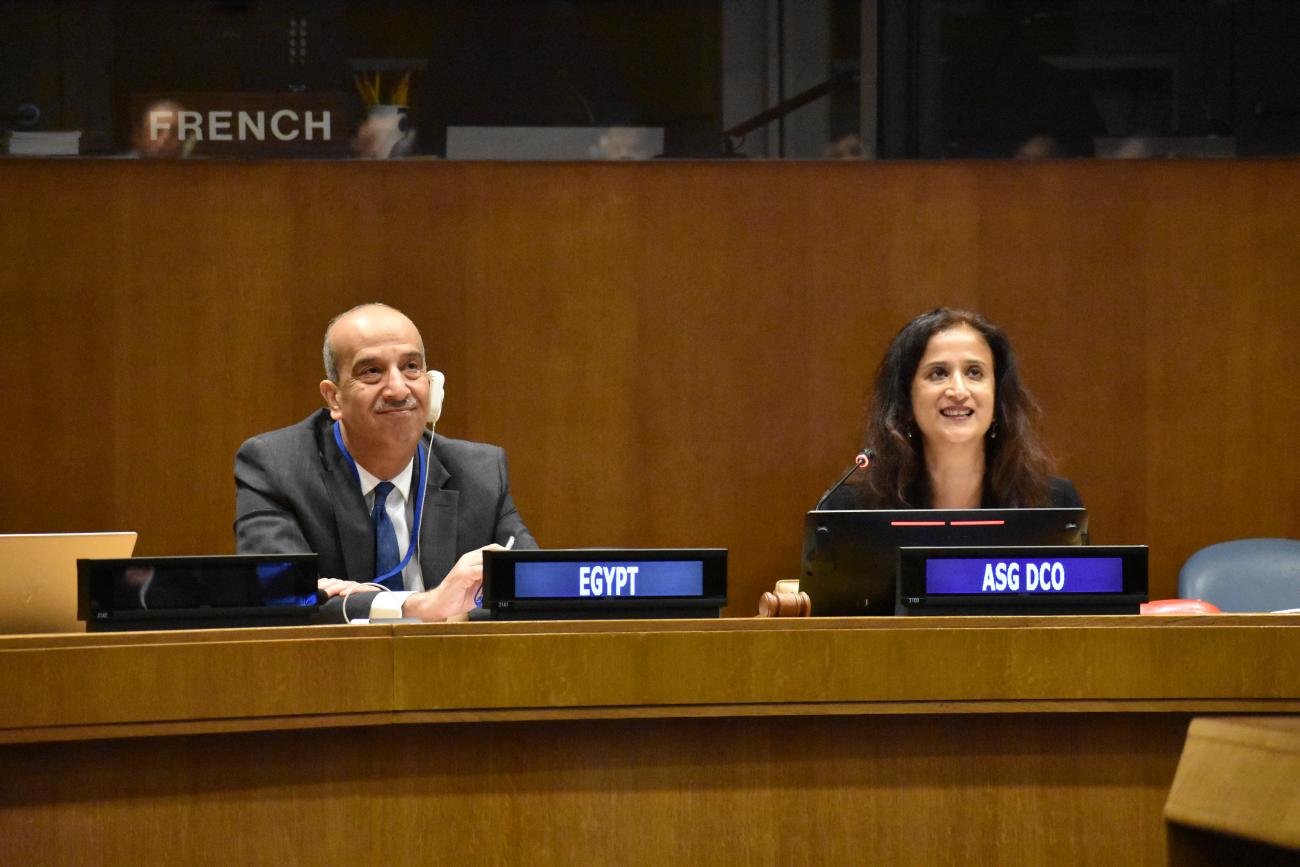 man and woman in suits sit next to each other in meeting room 