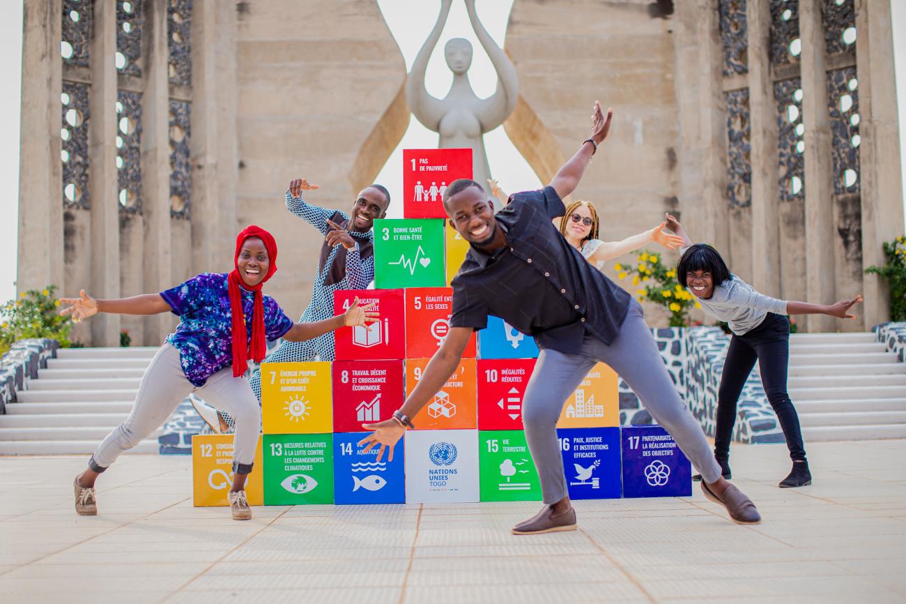 Group of children pose next to SDG blocks 
