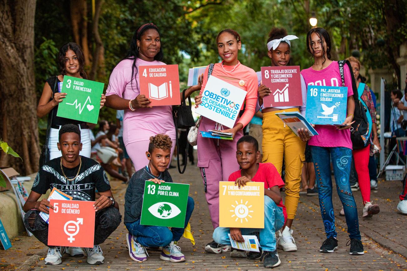 group of young people holding colourful SDG signs.
