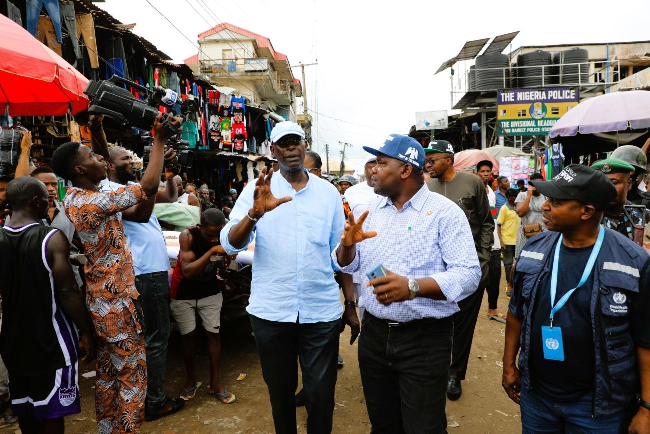 Two men walk through a rural market 