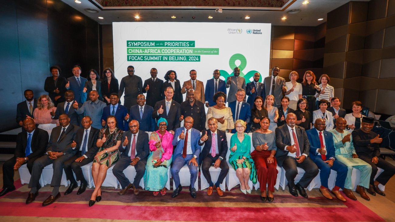 A group of people seated at an event with the words Africa Cooperatio Forum in the background