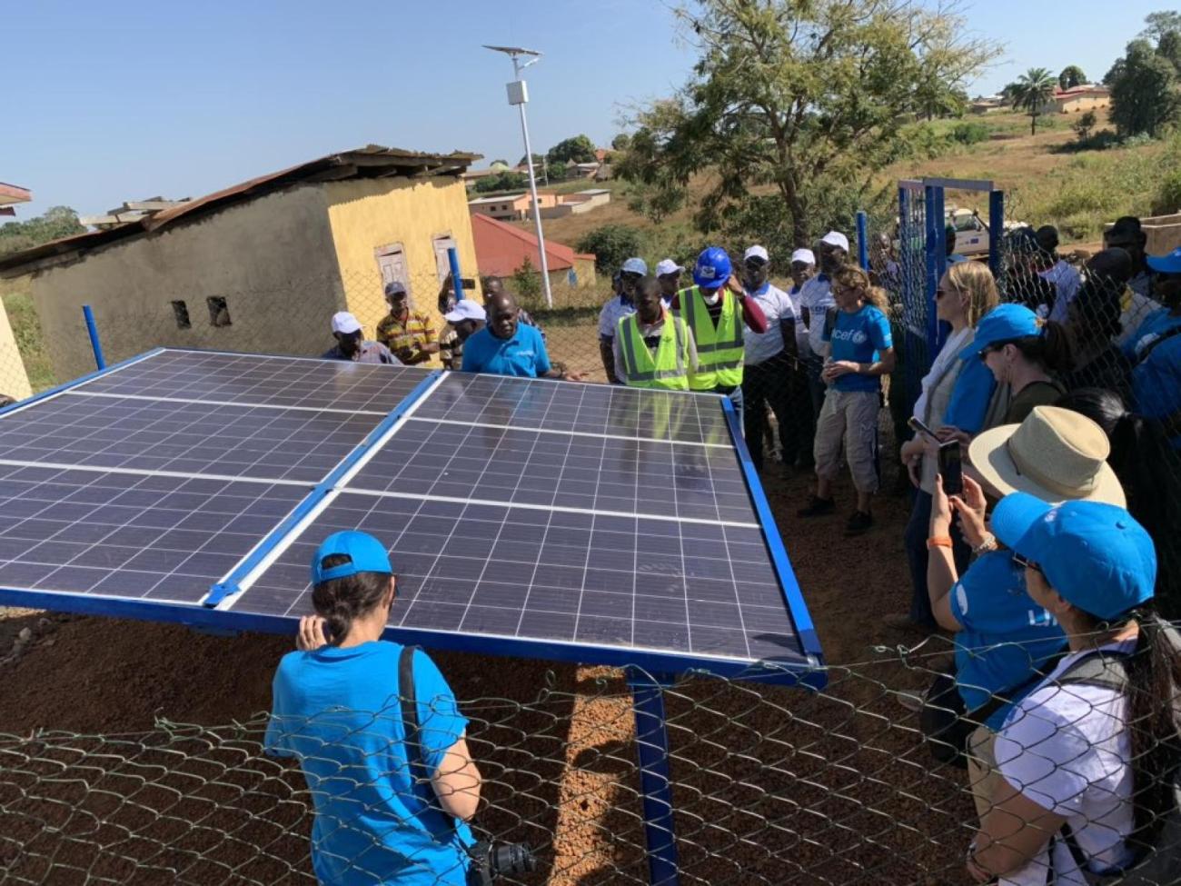 A group of people set up a solar panel