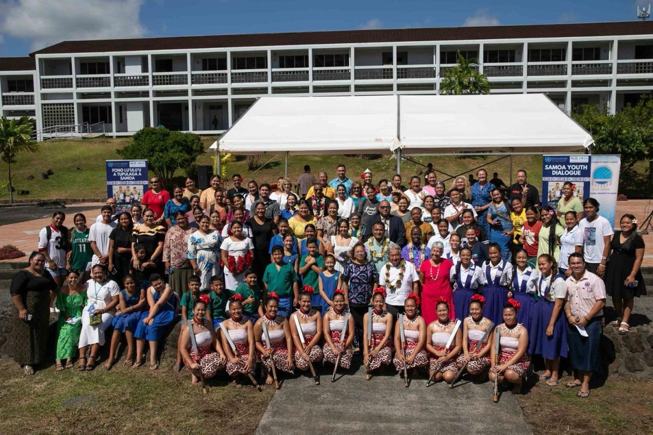 A group of people in an outdoor setting with young people in traditional dress and the UN Secretary-General.