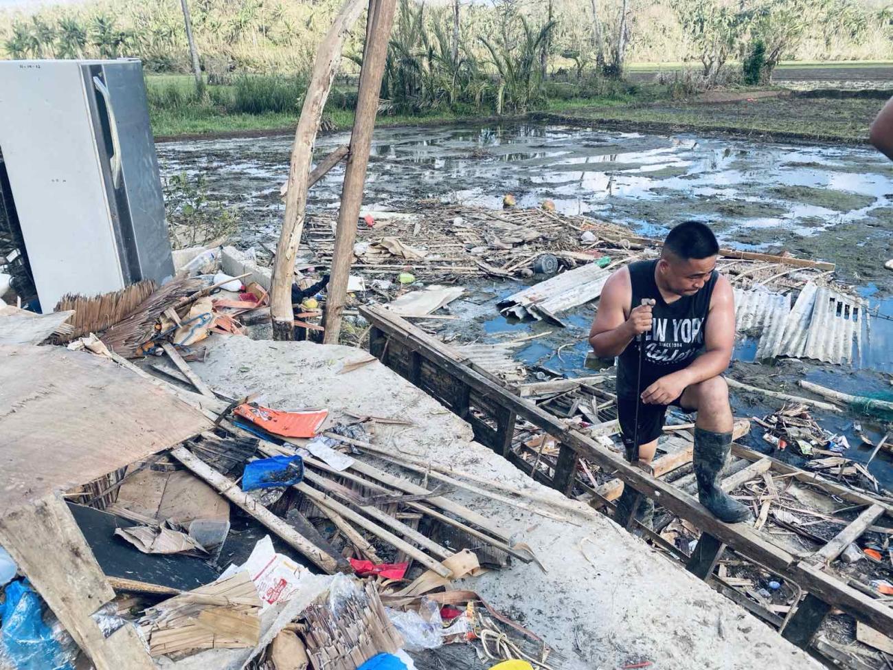 A man dealing with the aftermath of a Typhoon with debree etc 