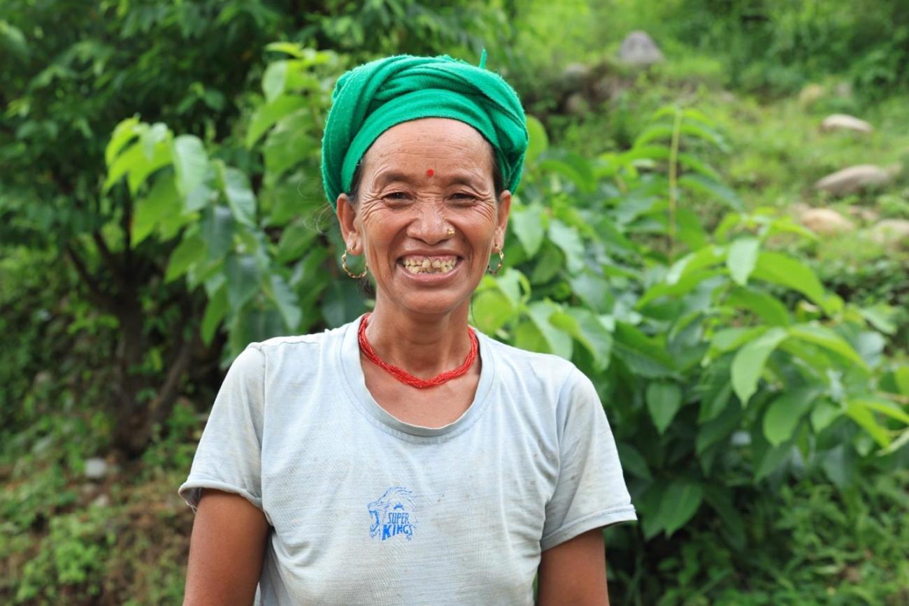 A woman looking at the camera and smiling in an outdoor setting