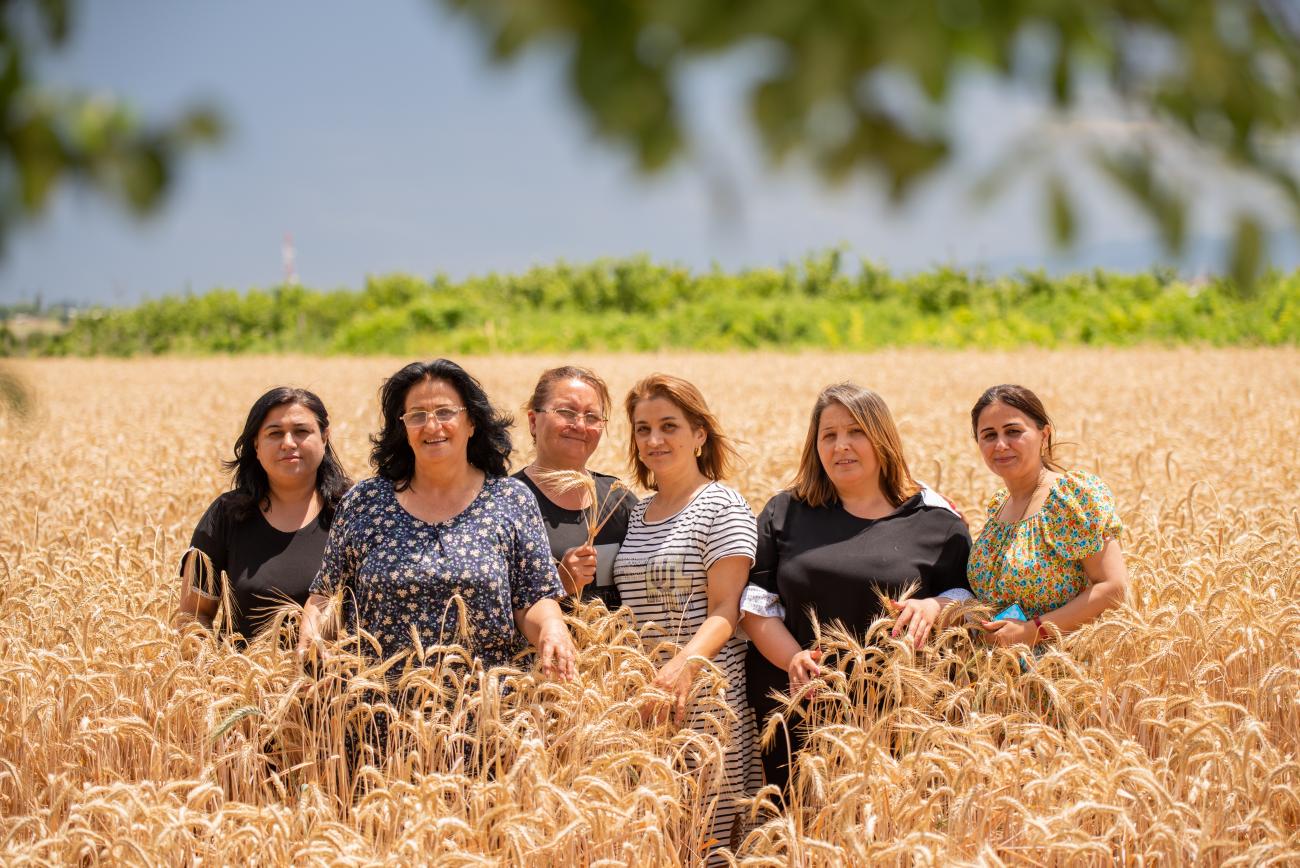 A group of women standing in a field and looking out at the camera