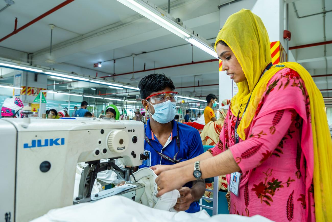 A woman and a man with a sewing machine 