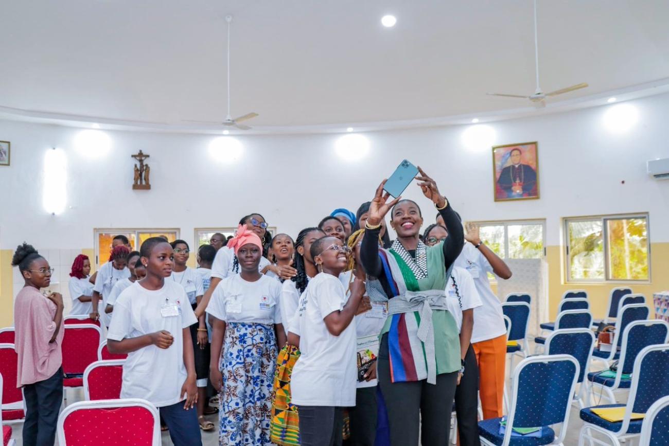A high-level UN official takes a photo with female high school students in Togo.