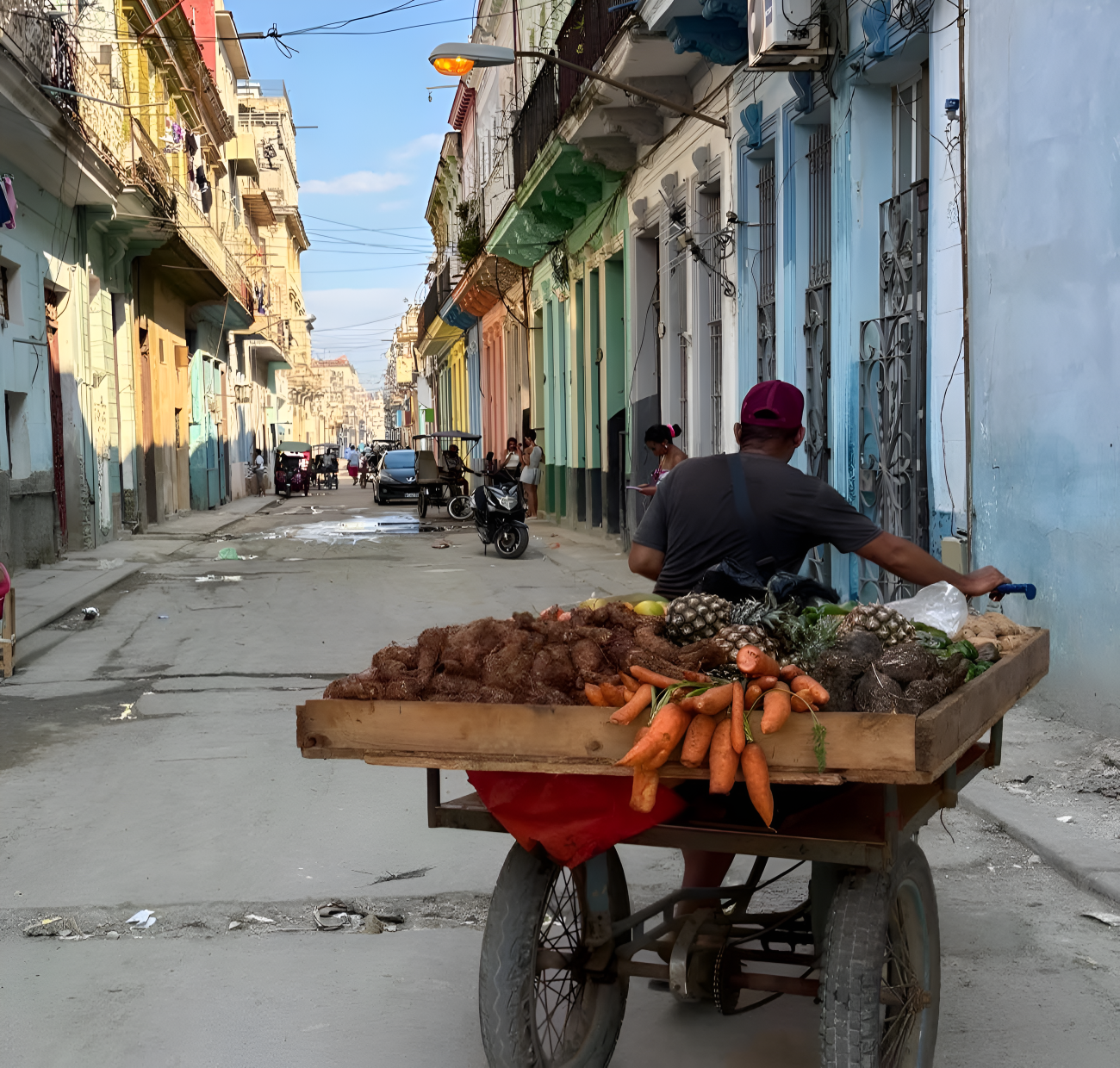 A man in Cuba rolls his fruit stand.
