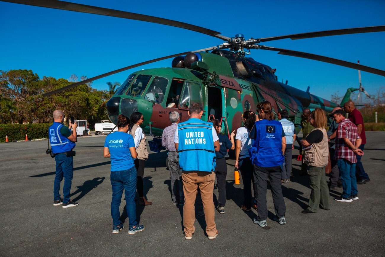 Members of the UN team in Cuba and partners in front of a helicopter.