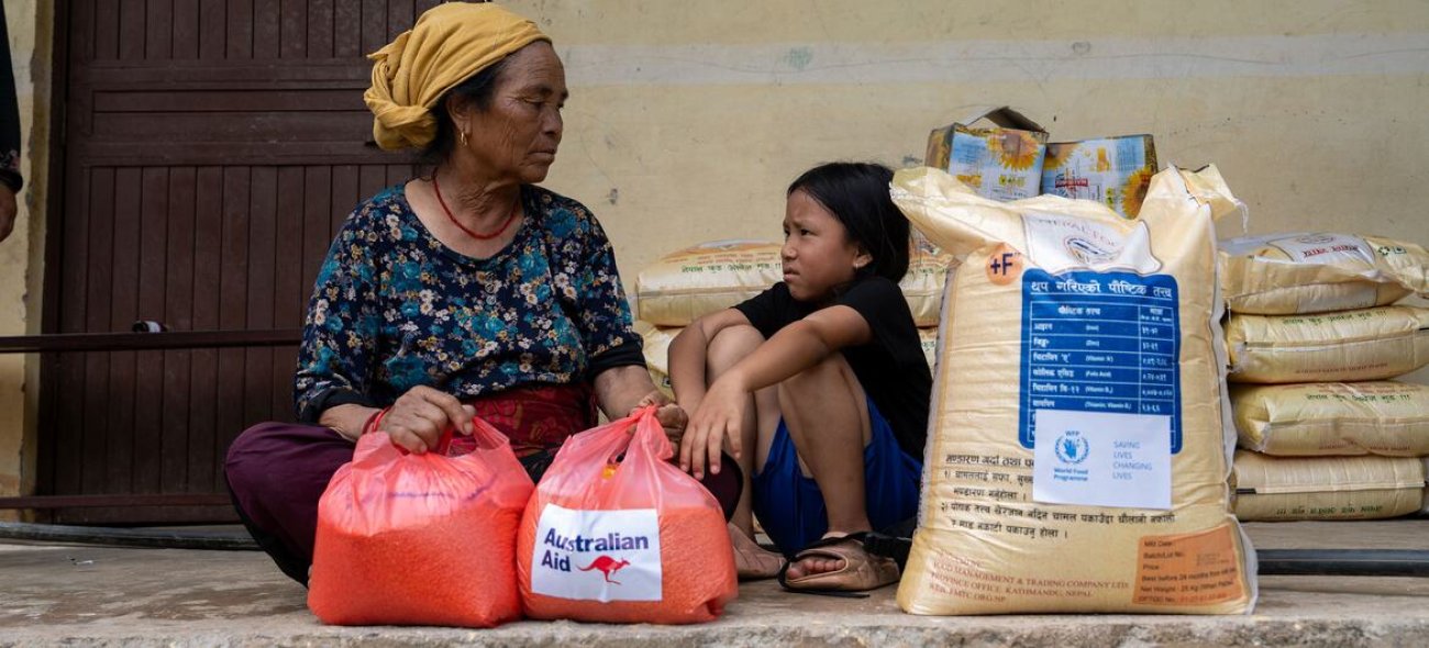 A woman and child in Nepal receive aid following floods.