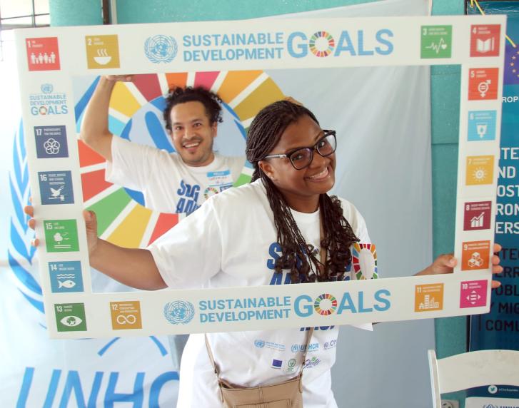 young boy and girl pose behind SDG cut out poster