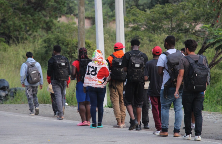 a group of young people walking on the side of the road
