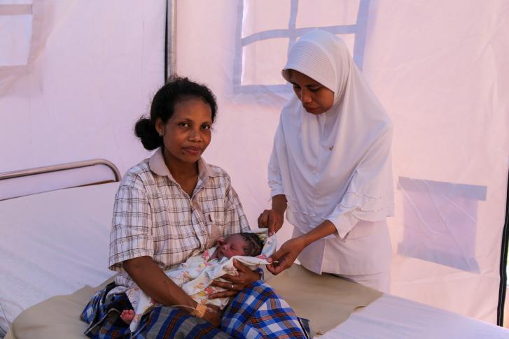 A nurse attending to a newborn and mother