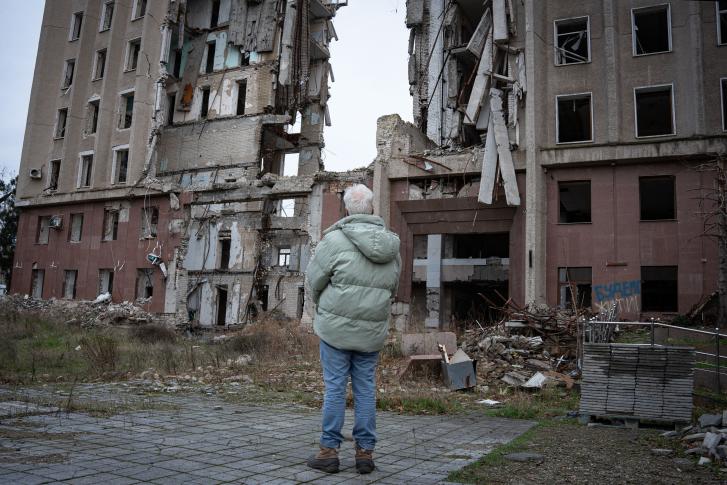 A high-level UN official surveils the damage done to a building in Ukraine.