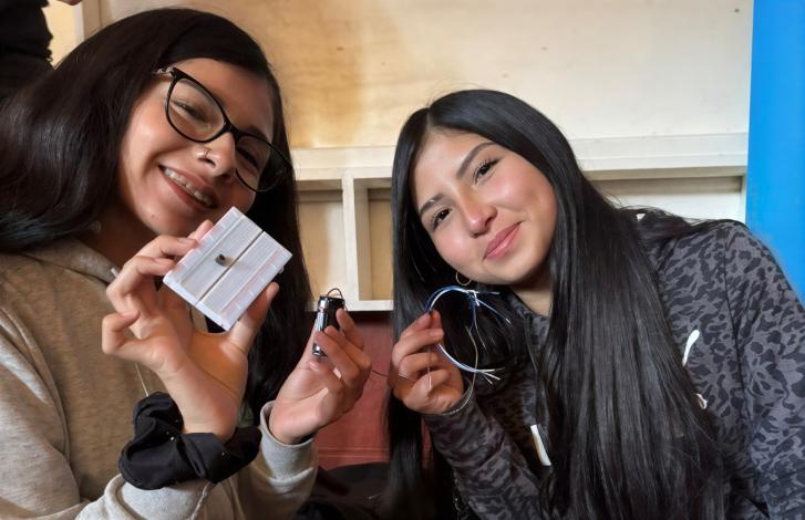 Two Chilean girls participate in a workshop about using electrical circuits for communications. 