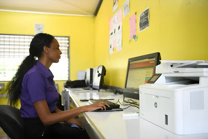 A woman in Jamaica uses a computer.
