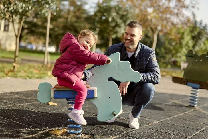 A father and his daughter at a playground in Montenegro.